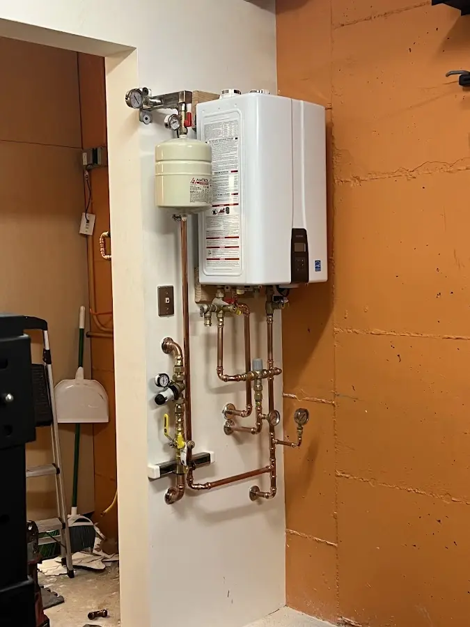 Plumbing technician inspecting water heater connections in Warner Robins